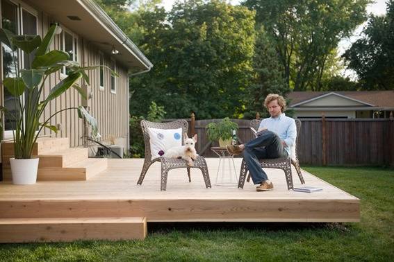 "Man and dog sitting on the chair in backyard."