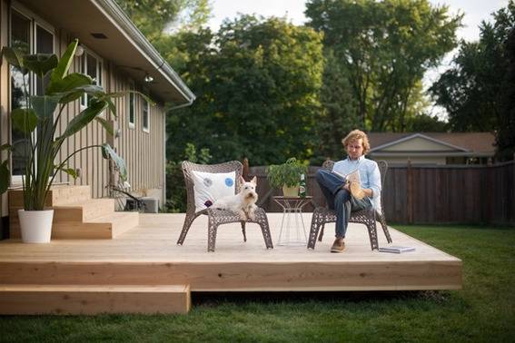 A guys sits and ponders on a back porch chair.