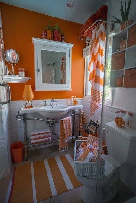 An orange-styled bathroom, with orange curtains and orange flooring/design overall.