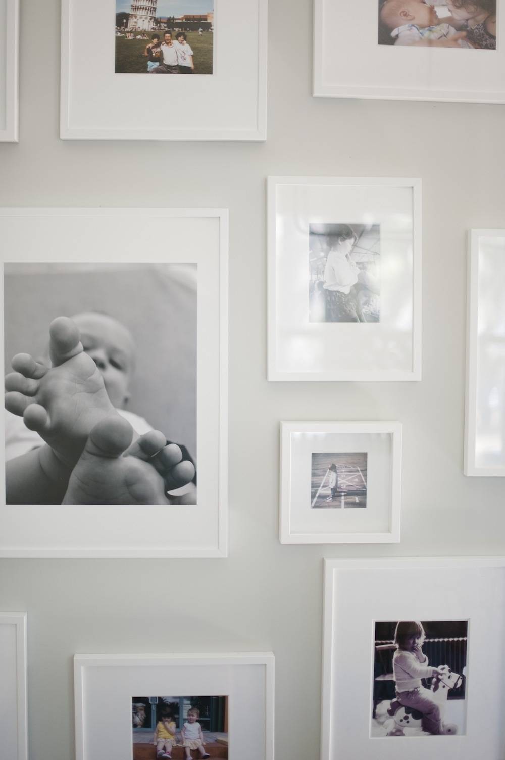 A wall having many different size images of a child.