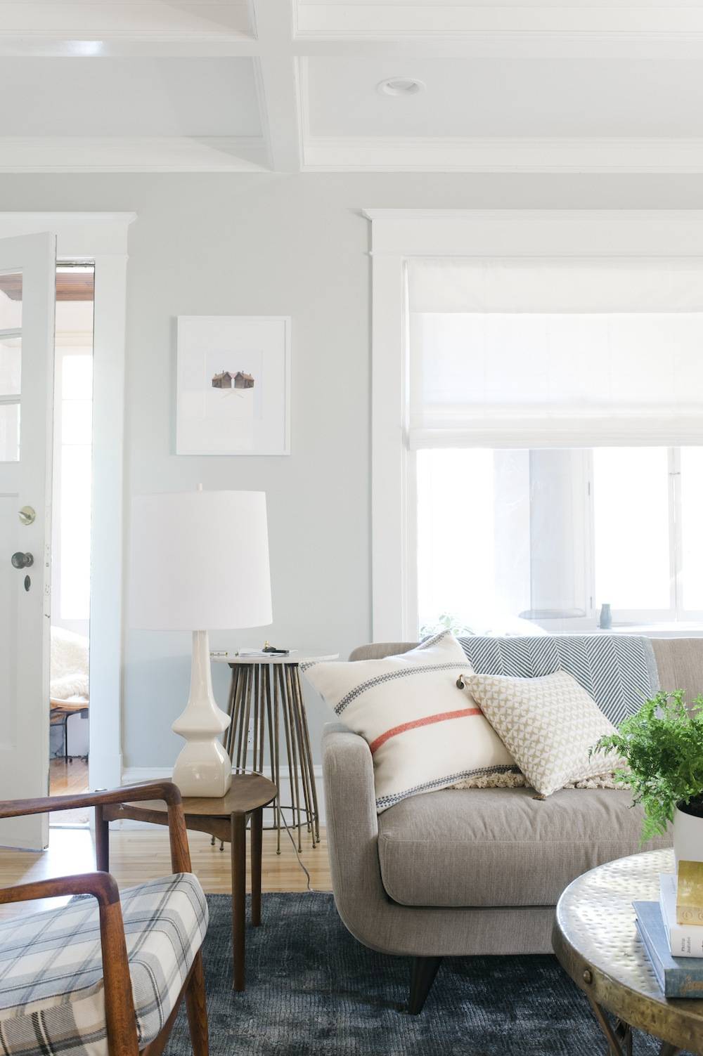 A grey couch and a chair are shown near the windows.