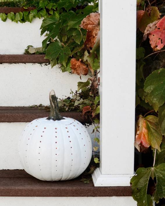 A wooden staircase has a white pumpkin on it.