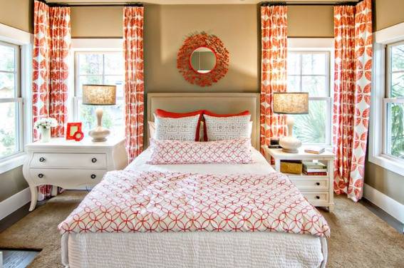 A large bedroom is decorated with orange and white.