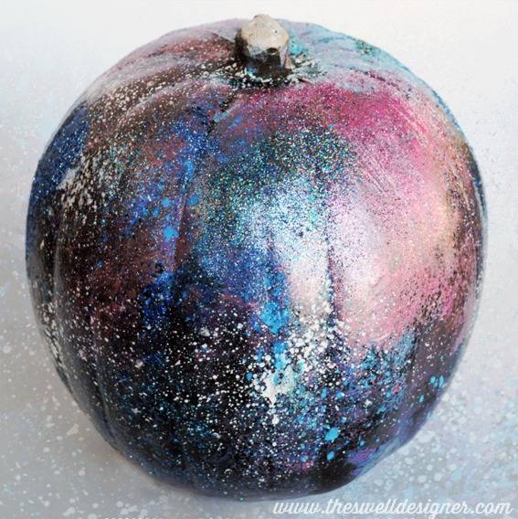 Pumpkin painted with colors and sparkles resembling a night sky.
