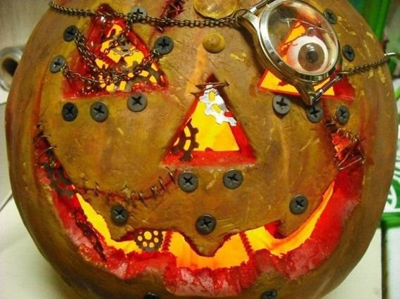 A pumpkin with a large red smile and scary objects sticking out.