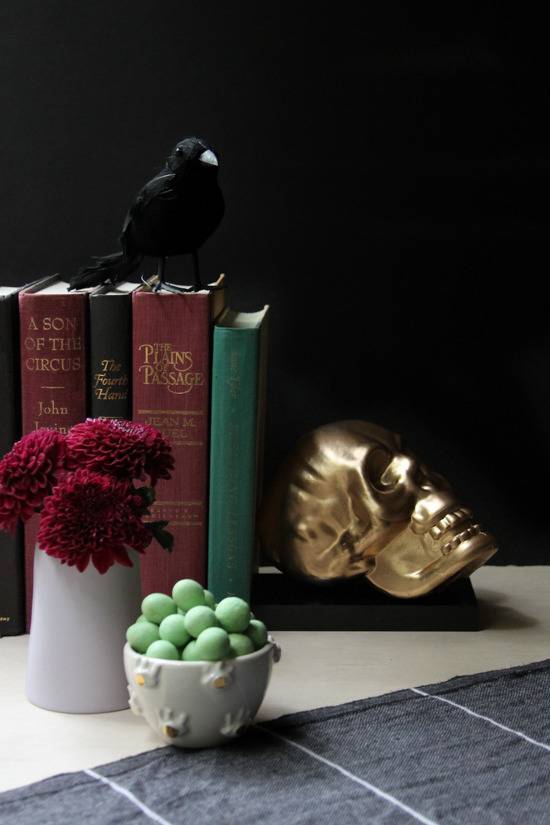 A gold skull used as a bookend on a counter.