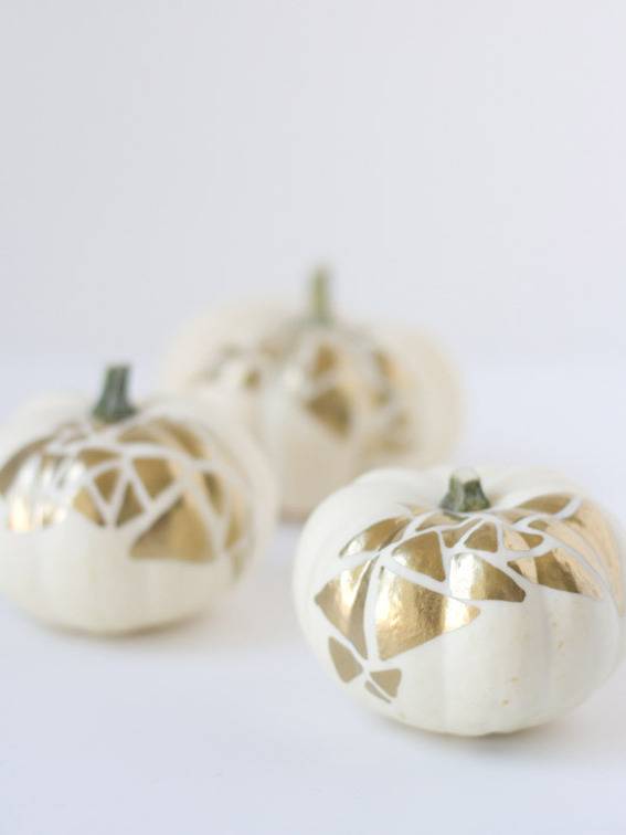 Three little pumpkins paint white with a gold leaf.