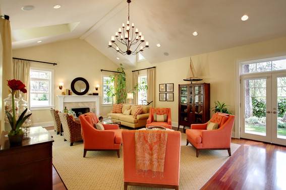 A fancy living room has orange, soft chairs.