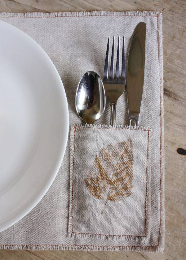 Spoon, fork and knife are placed in a dinning table napkin pocket and plate at the top.