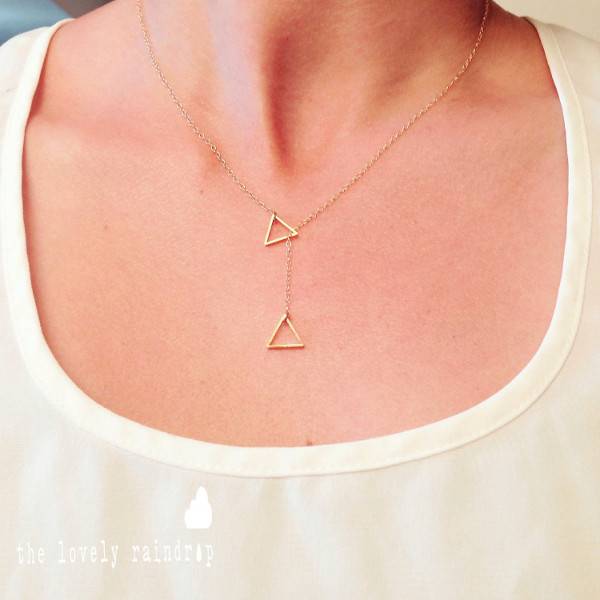 A person is wearing a chain with triangles on it.