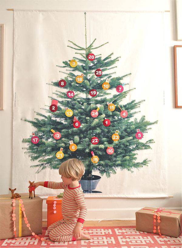 Child playing with reindeer toys on cardboard box near decorated tree.