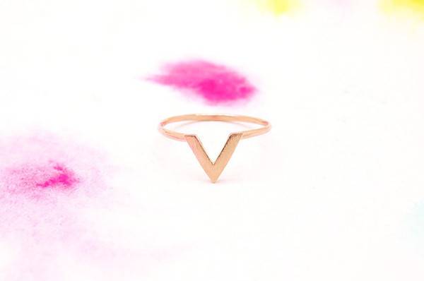 A pink blob is seen over a v shaped golden ring.