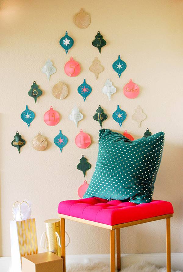 Paper lantern decorations on wall in shape of pine tree near cushioned stool with pillow.