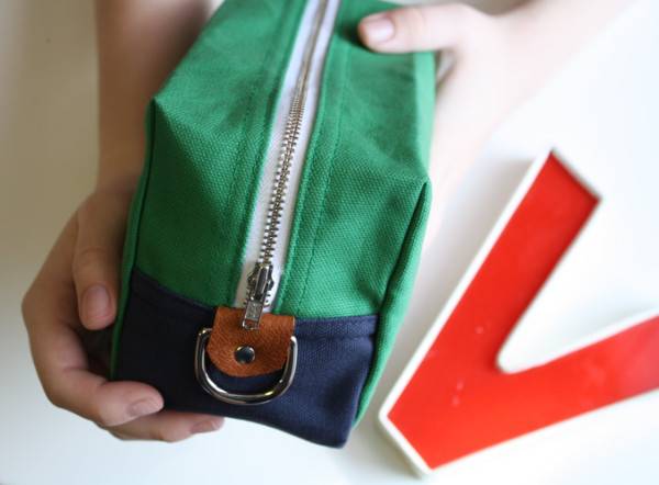 A person is showing green color zip bag.