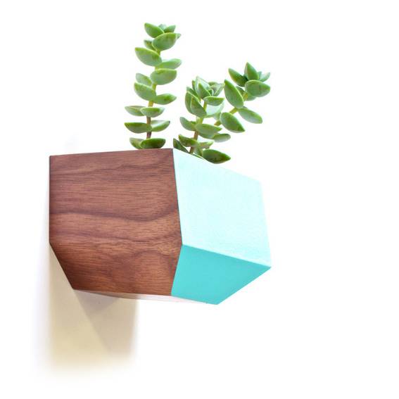 A brown and blue planter has a green plant in it.