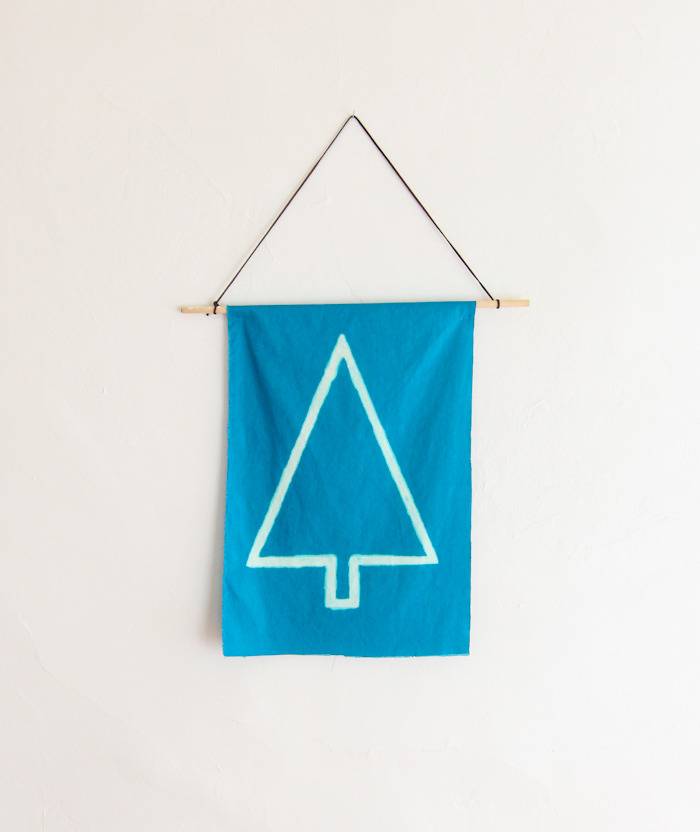 A blue towel with a triangle on it hanging from the wall.