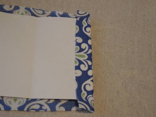 Blue and white fabric with a white sheet on it sitting on top of a carpet.