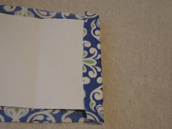 Blue and white fabric with a white sheet on it sitting on top of a carpet.