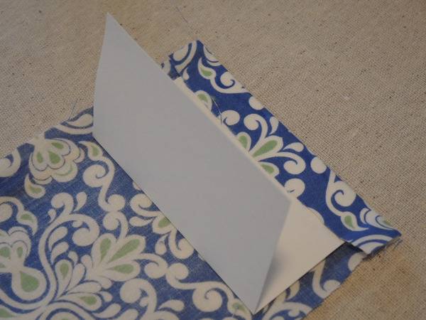 A blue fabric envelope is being put together.