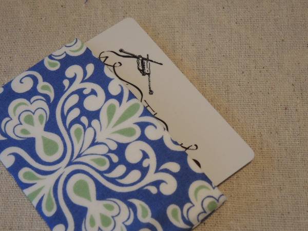 A folder with blue, green and white flower designs has a piece of paper sticking out.