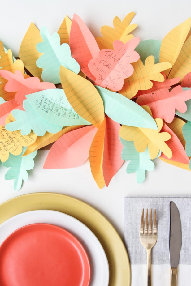 Pastel colored table designs next to pastel colored plates on a table.