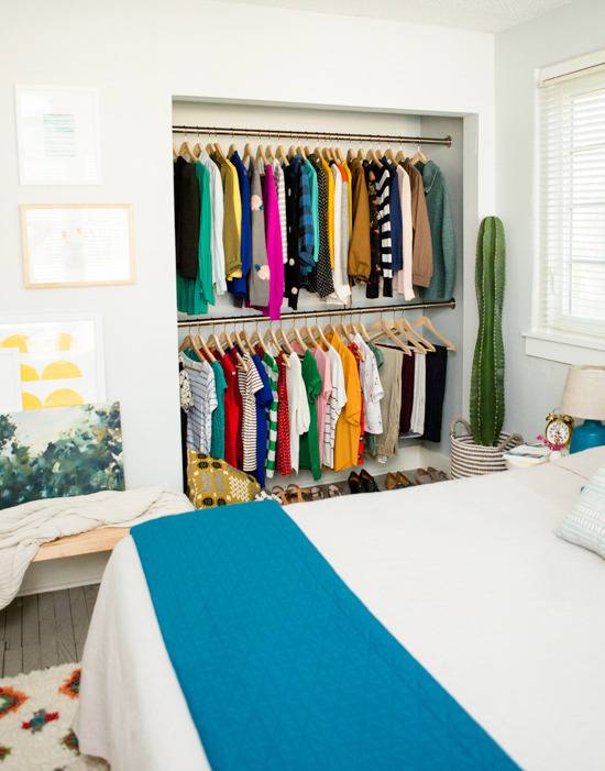 Closet organization in a bedroom, the closet has two racks for the clothes.