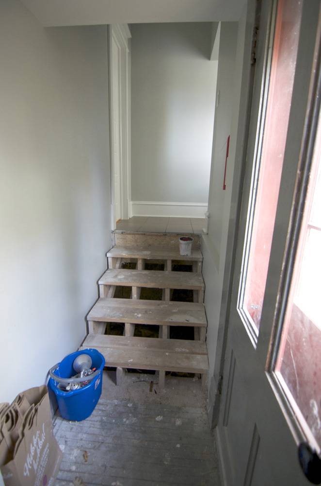 Wooden stair frame with carpet removed in entryway.