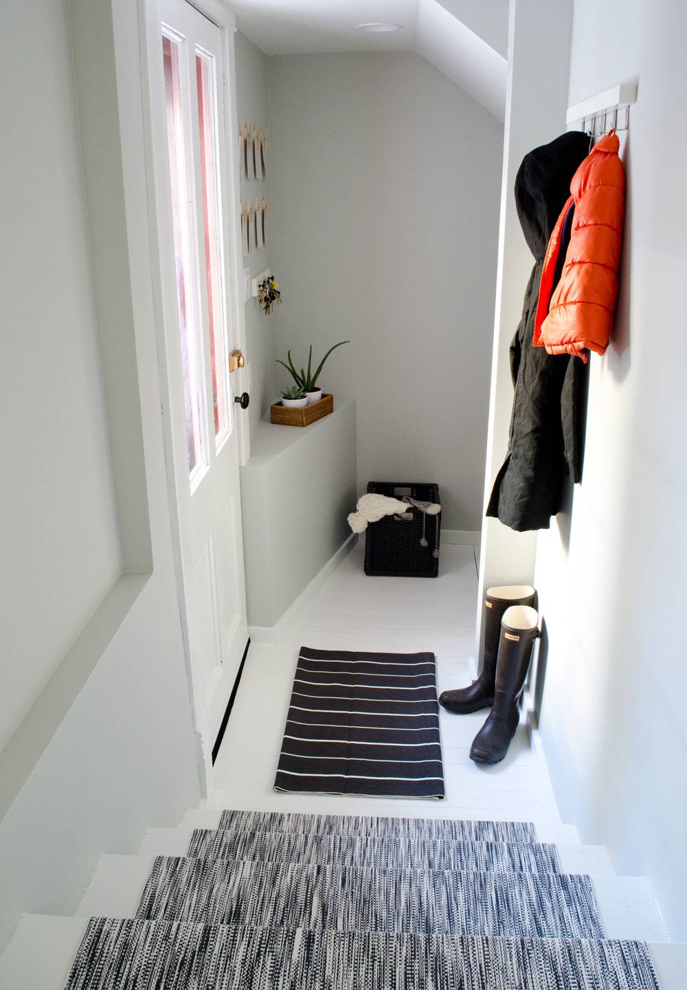Entryway makeover with painted floors and black and white rugs.