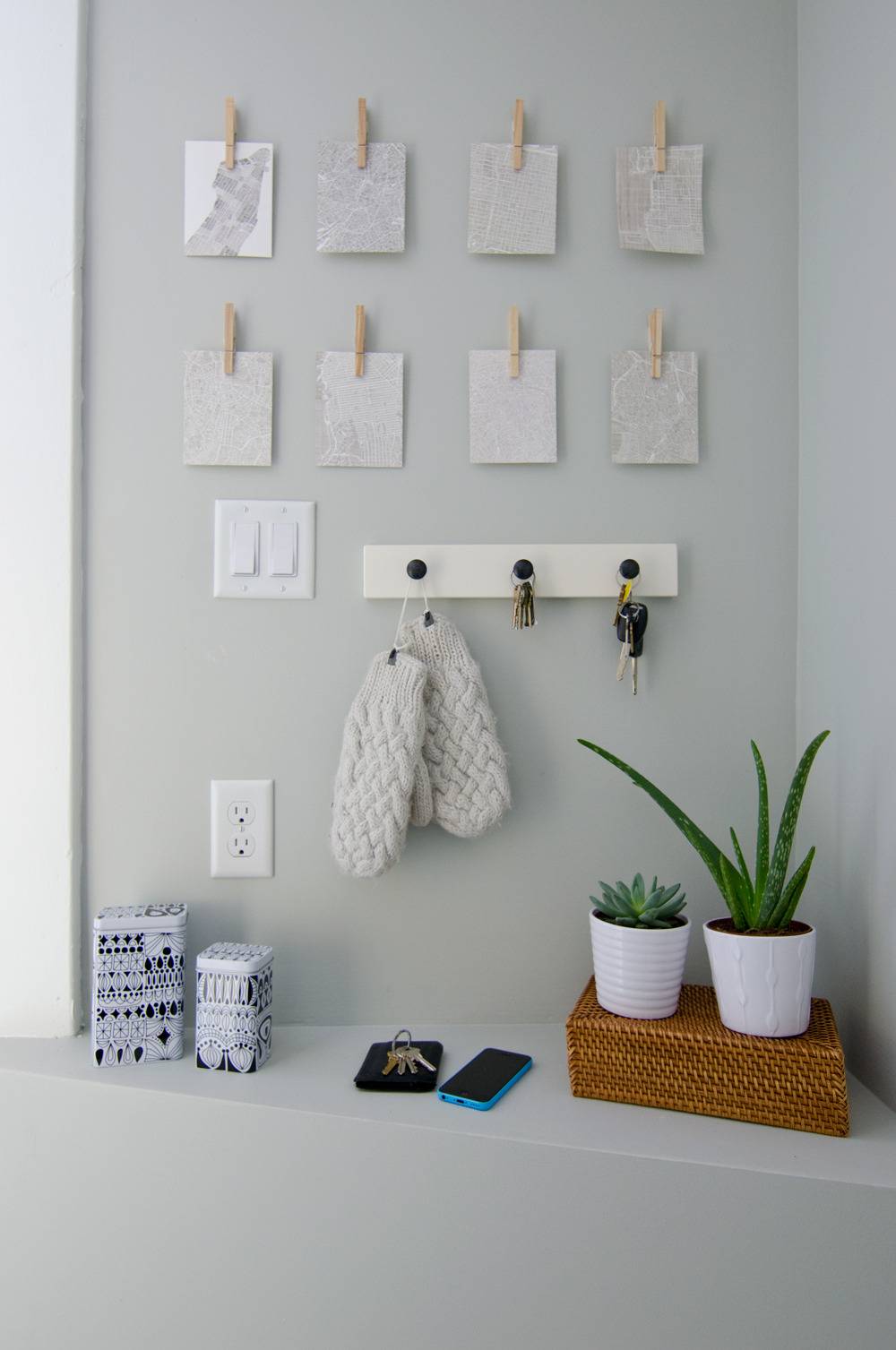 An entryway with wall hangings and potted plants.
