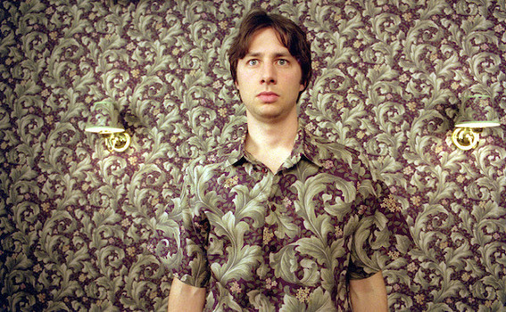 "Young man posing with the dress  related to the wall paper design."