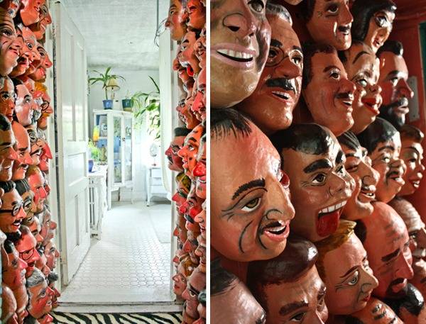 A home with masks of men adorning the walls.