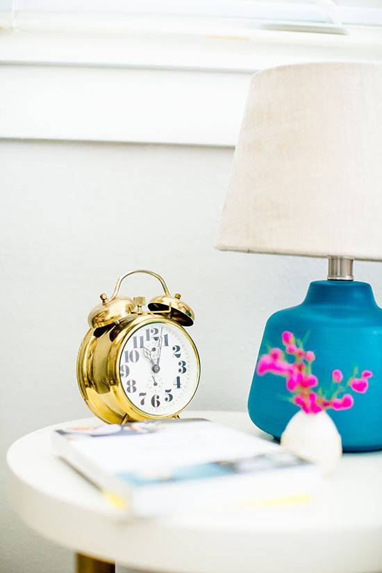 "Alarm clock and nightstand is on the white surface table."