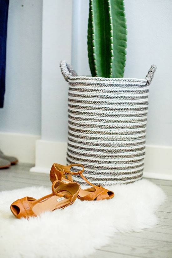 "White carpet with sandals and rope plant basket."