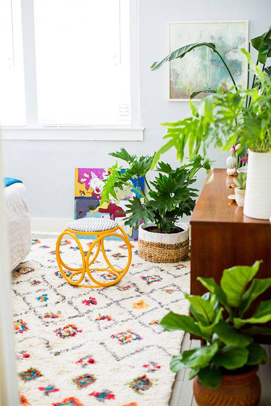 Corner of a bedroom with lots of green plants.