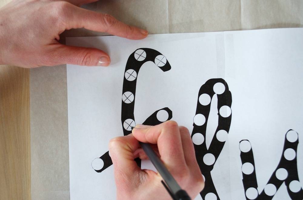 A person draws with black ink in decorative font.