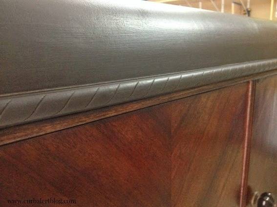 A wooden item has a dark gray top.