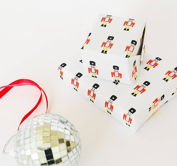 Disco ball ornament near presents wrapped with Nutcracker wrapping paper.