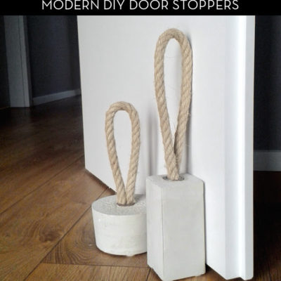 Two modern white door stoppers made of concrete and rope.