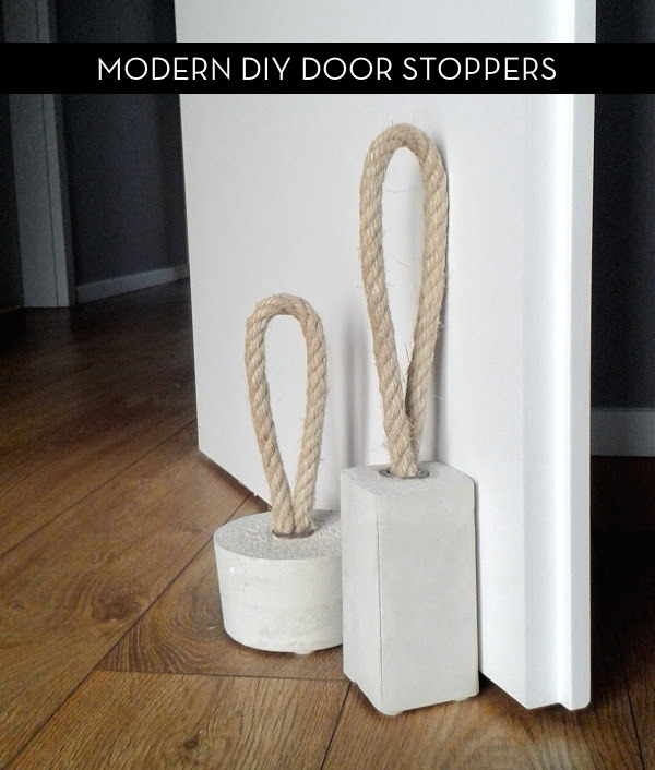 Two modern white door stoppers made of concrete and rope.