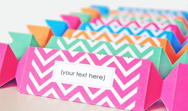 Group of card stock paper shaped like piece of candy with chevron stripes.
