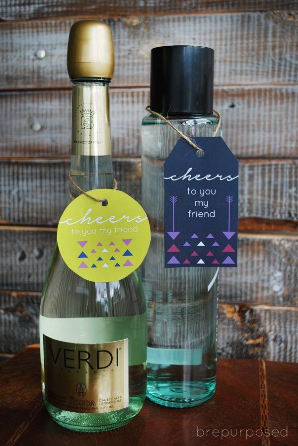 Wine is next to a tall bottle on a wooden table.