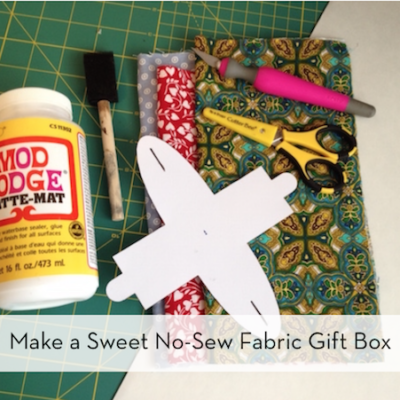 Cutting paper, glue, scissor, knife, fabrics are aside.