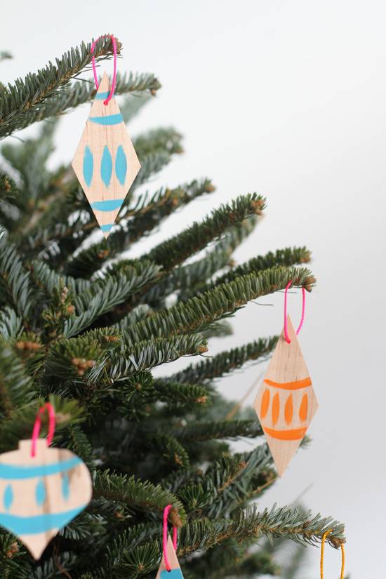 Veneer ornaments hanging to the leaves of the tree.