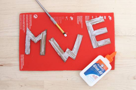Cardboard alphabets on red color paper applied glue with paint brush.