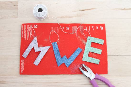 Colorful cardboard alphabetical hangings with rope on red paper.