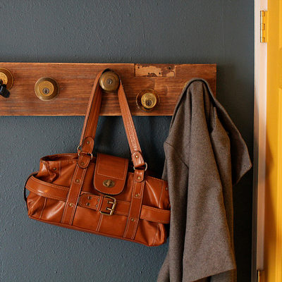 A hanger with a rustic bag and a coat beside the door