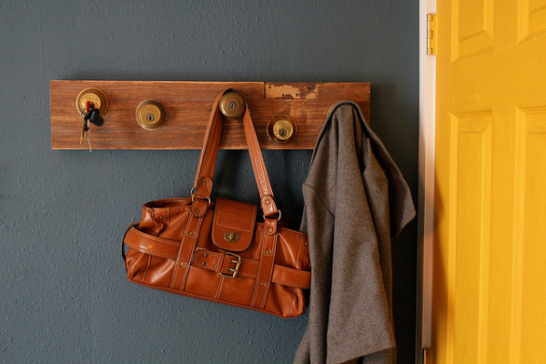 A hanger with a rustic bag and a coat beside the door