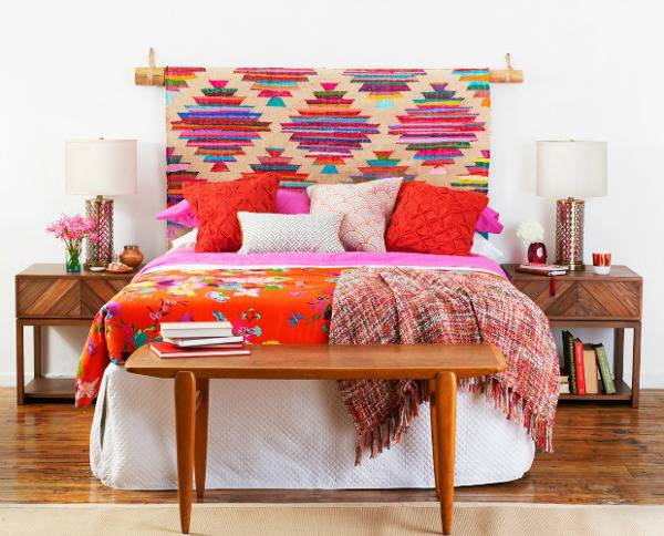 Multicolored diamond shaped headboard bed and bedside table lamps and potted plants with book racks.