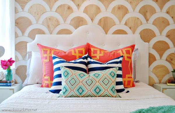Wood and white color combination headboard with designer pillows on bed.