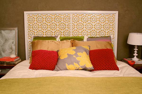 Hexagon designed headboard of a bed with designer pillows.